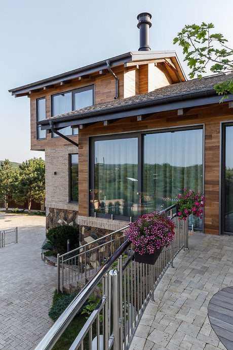 Contemporary two-story home with large glass windows and wooden accents.
