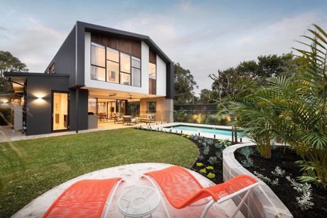 Contemporary two-story home with large windows and a pool.