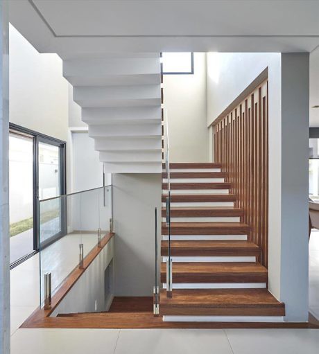 Modern staircase with floating steps, glass railing, and wooden accents.