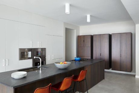 Minimalist kitchen with sleek cabinets and dark island.