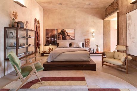 Earthy-toned bedroom with modern furniture and a patterned area rug.