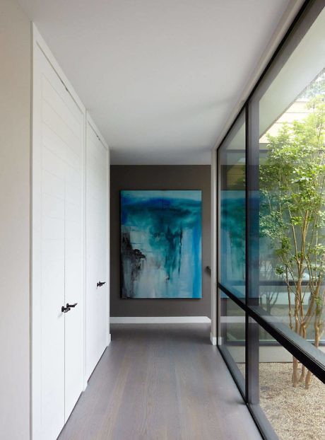Sleek hallway with floor-to-ceiling windows and abstract art.