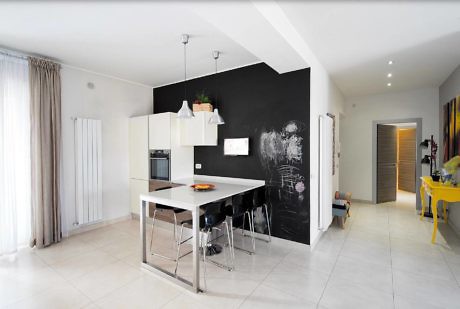 Minimalist kitchen with white décor and chalkboard wall.