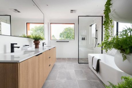 Sleek bathroom with dual vanity, glass shower, and freestanding tub