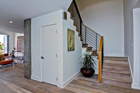 Contemporary home interior with sleek staircase and hardwood floors.