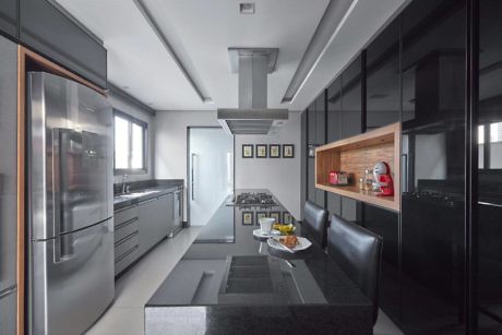 Modern kitchen with stainless steel appliances, black cabinets, and a central island.
