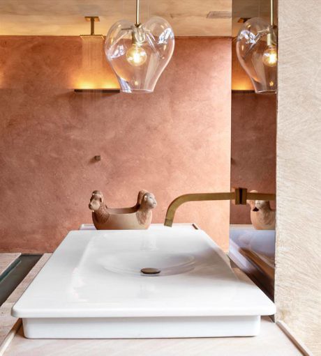 Elegant bathroom with terra-cotta walls, heart-shaped pendant lights, and modern