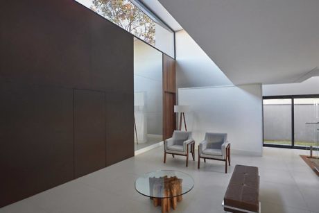 Modern minimalist living room with large windows and neutral tones.