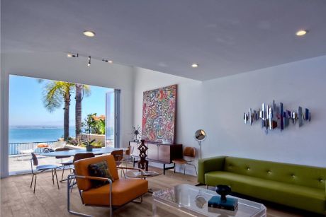 Modern living room with ocean view, contemporary furniture, and wall art.