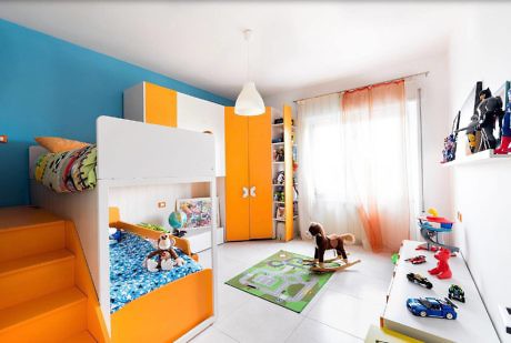 Brightly colored children's bedroom with bunk bed, toys, and play mat.