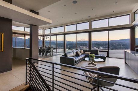 Modern living room with large windows and a mountain view.