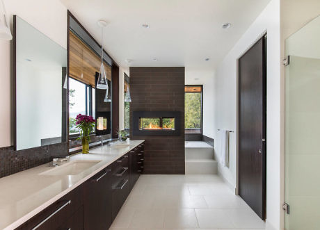 Modern kitchen interior with dark cabinets and large windows.