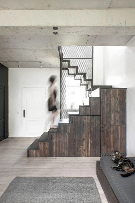 Modern staircase with dark wood steps and a cat lounging at the bottom.
