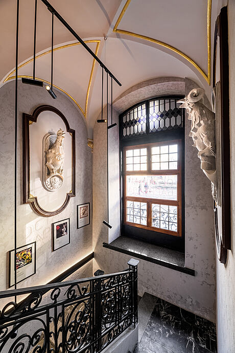 Ornate architectural details, intricate iron railings, and a decorative arched window.