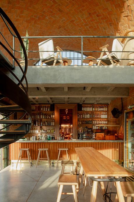 Modern café interior with spiral staircase and upper seating area.