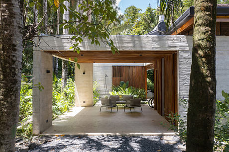 Modern outdoor patio with wooden accents surrounded by lush greenery.