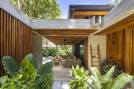 Modern wooden outdoor patio with lush plants and furniture.