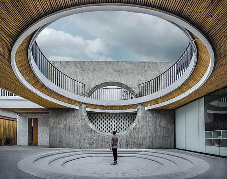 Modern interior courtyard with circular walkways and a person standing center.