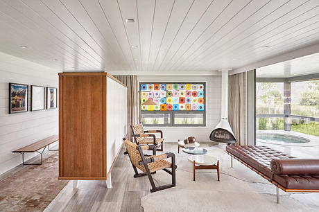 Modern living room with colorful wall art, fireplace, and sleek furniture.