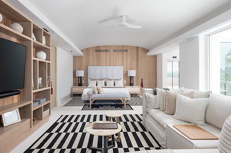 Modern bedroom with a black and white rug, wooden shelving, and neutral tones