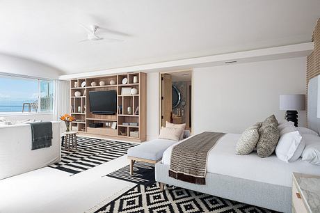 Contemporary bedroom with ocean view and geometric rug.