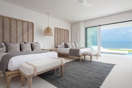 Contemporary bedroom with sea view, neutral tones, and minimalist decor.