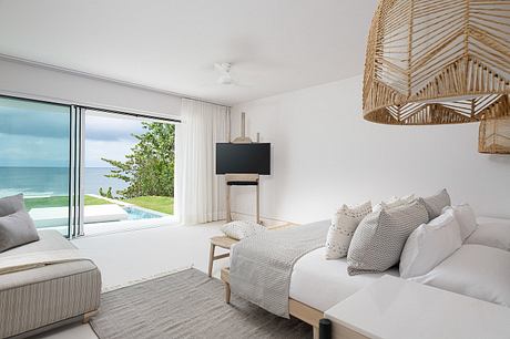 Bright seaside bedroom with minimalistic design and ocean view.
