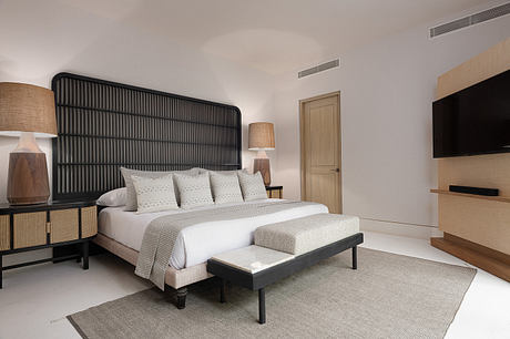Contemporary bedroom with a black bed frame, beige walls, and elegant decor.