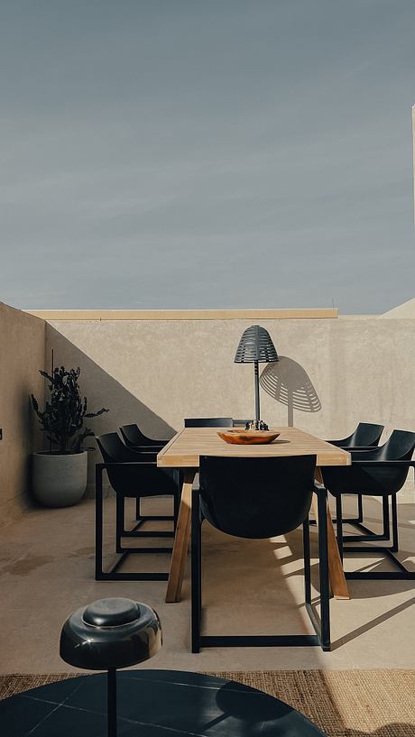 Minimalist outdoor dining area with sleek furniture and neutral tones.