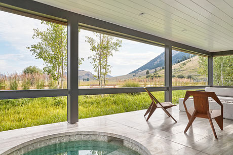 Minimalist interior with large windows overlooking nature.