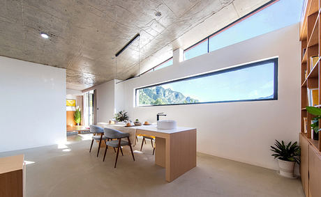 Modern kitchen interior with long window view and minimalist furniture.