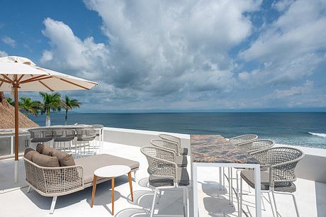 Oceanfront terrace with modern outdoor furniture and umbrella