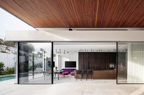 Modern interior with clean lines, wood-paneled ceiling, and sleek kitchen cabinetry.