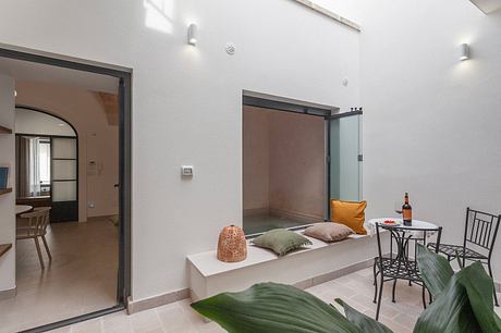 Modern, minimalist interior design with sliding doors, cozy seating area, and decorative elements.