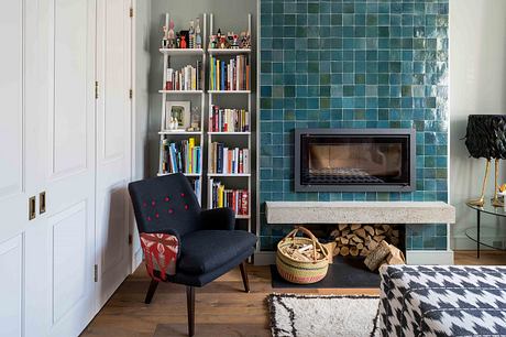 Cozy living room with vibrant green tile wall, built-in bookshelf, and modern fireplace.