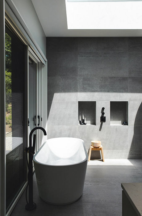 Sleek, modern bathroom with minimalist design, white freestanding tub, and recessed shelves.