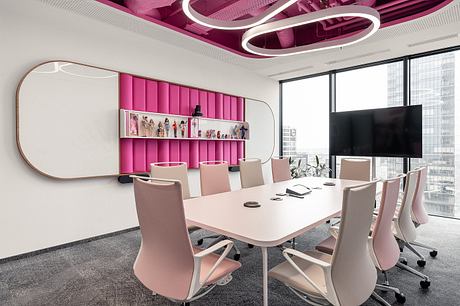 Vibrant, modern office space with sleek pink furniture, dynamic lighting, and city views.