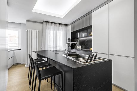 Modern kitchen with sleek black countertops, built-in appliances, and minimal decor.