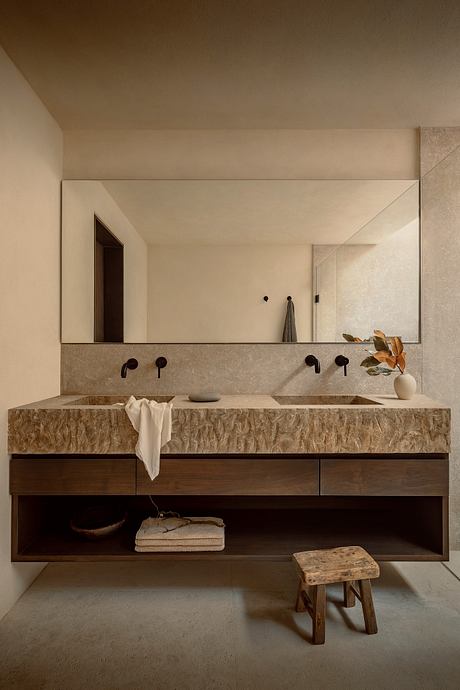Minimalist bathroom with sleek stone vanity, recessed lighting, and rustic accents.