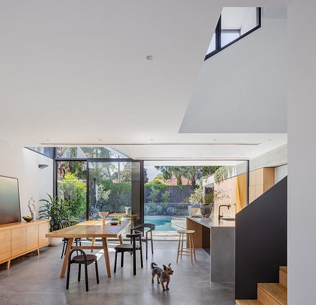 Airy open-concept living space with sleek lines, large glass walls, and an inviting pool.