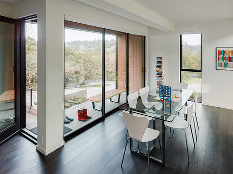 Airy modern dining area with glass sliding doors, wood accents, and colorful decor.
