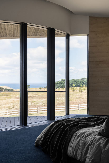 Spacious bedroom with large windows offering panoramic views of the countryside.