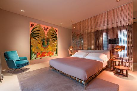 Vibrant contemporary bedroom with tropical artwork, patterned wall, and modern furnishings.