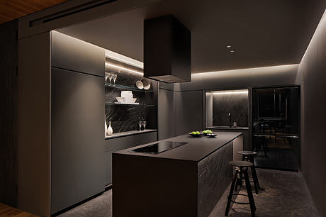 Sleek, modern kitchen with dark marble countertops, recessed lighting, and minimalist cabinetry.