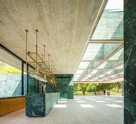 Dramatic wood and glass architecture with striking green marble accents and bold lighting.