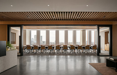 Spacious, modern conference room with floor-to-ceiling windows, wooden slat ceiling, and sleek furniture.