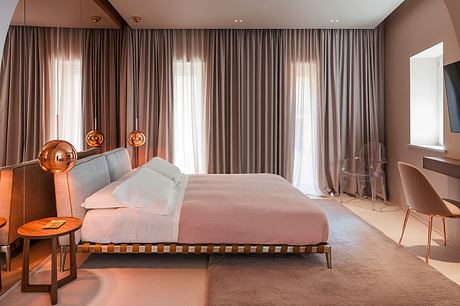 Luxurious bedroom with plush curtains, modern lighting fixtures, and sleek furniture.