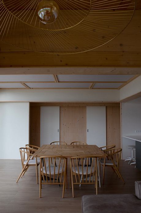 A wooden dining table and chairs with a domed ceiling and geometric patterns.
