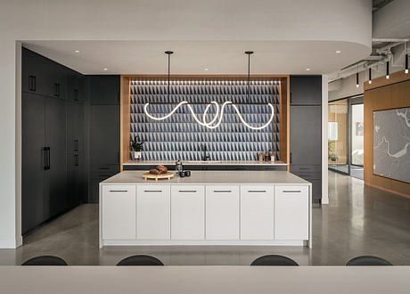 Modern kitchen with minimalist black and white geometric patterns, sleek cabinetry, and pendant lighting.