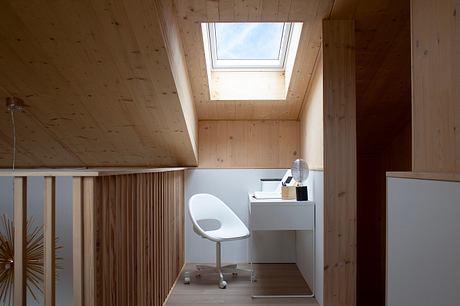 Cozy wooden loft with skylight, minimalist furniture, and sleek design elements.